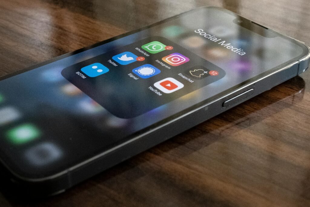 Smartphone exibindo aplicativos populares de redes sociais, representando o potencial de integração de um mobile app suicide prevention app como o OTX-2022 para ajudar at-risk individuals com suporte digital e terapias baseadas em cognitive behavior therapy (CBT)
